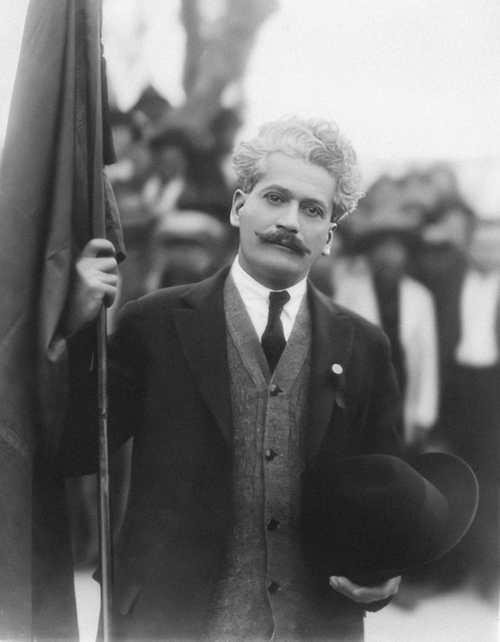 a black and white photo of a man holding a flag