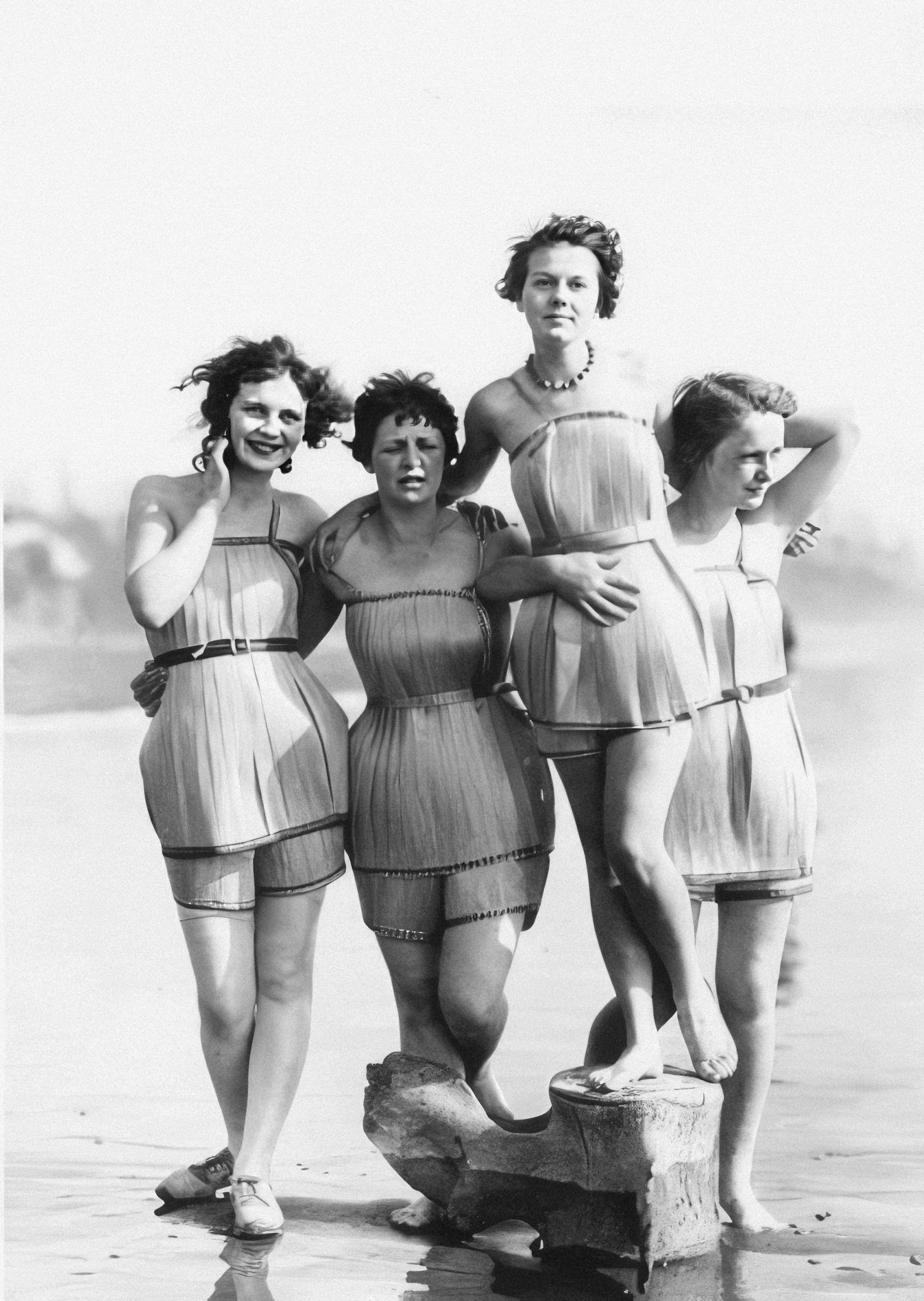 a group of women standing next to each other on a beach