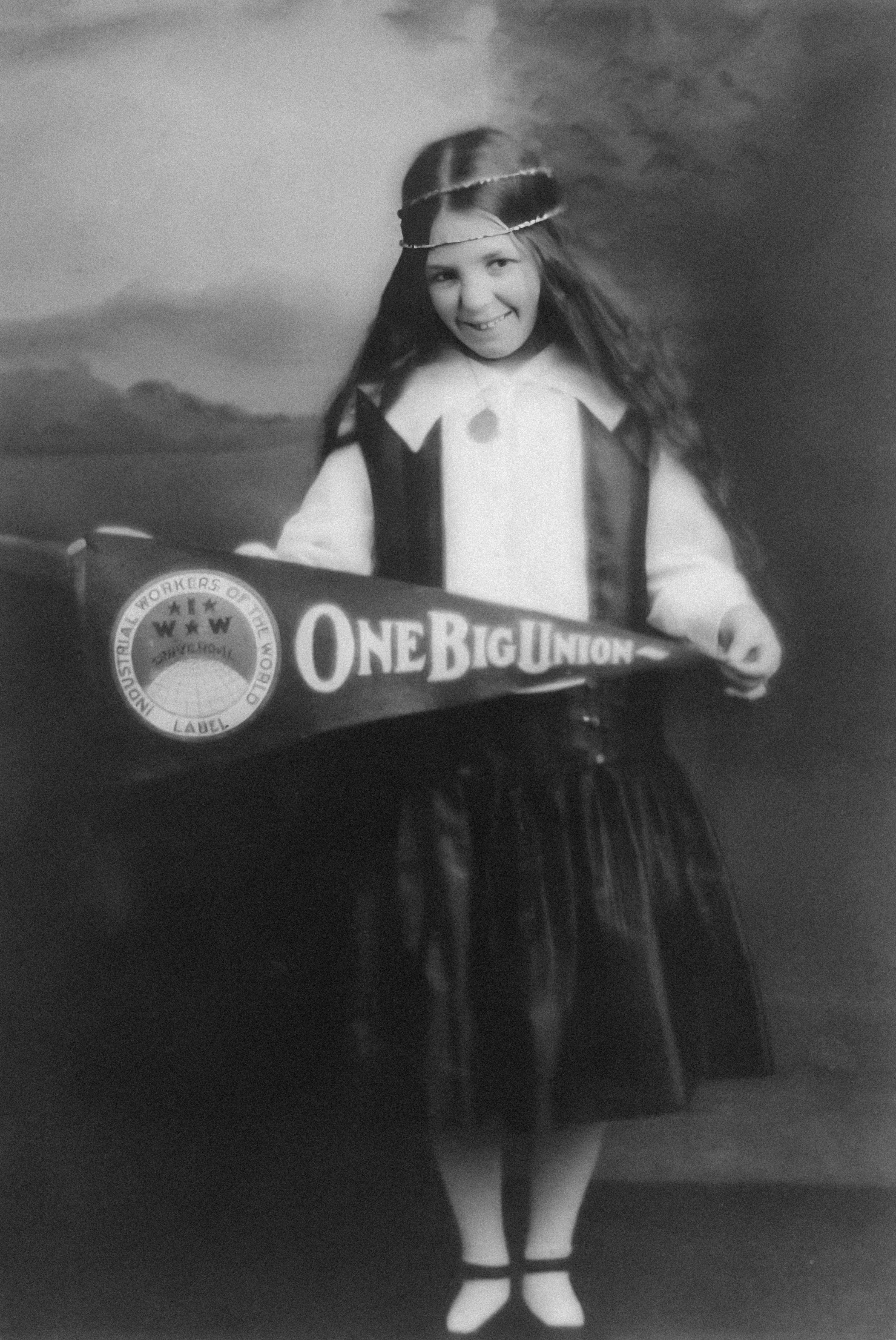 a little girl in a costume holding a sign
