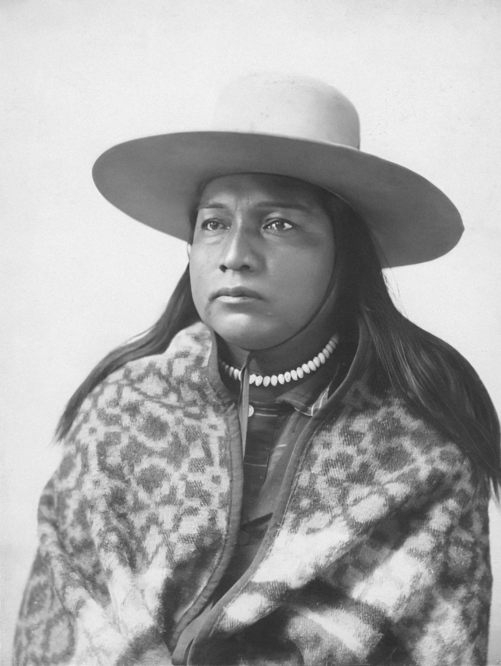 a black and white photo of a woman wearing a hat