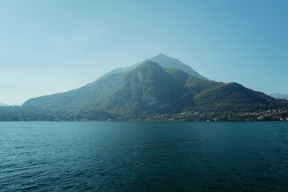 a large body of water with a mountain in the background