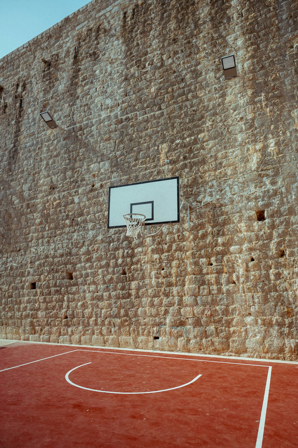 벽돌 벽 앞의 농구 코트