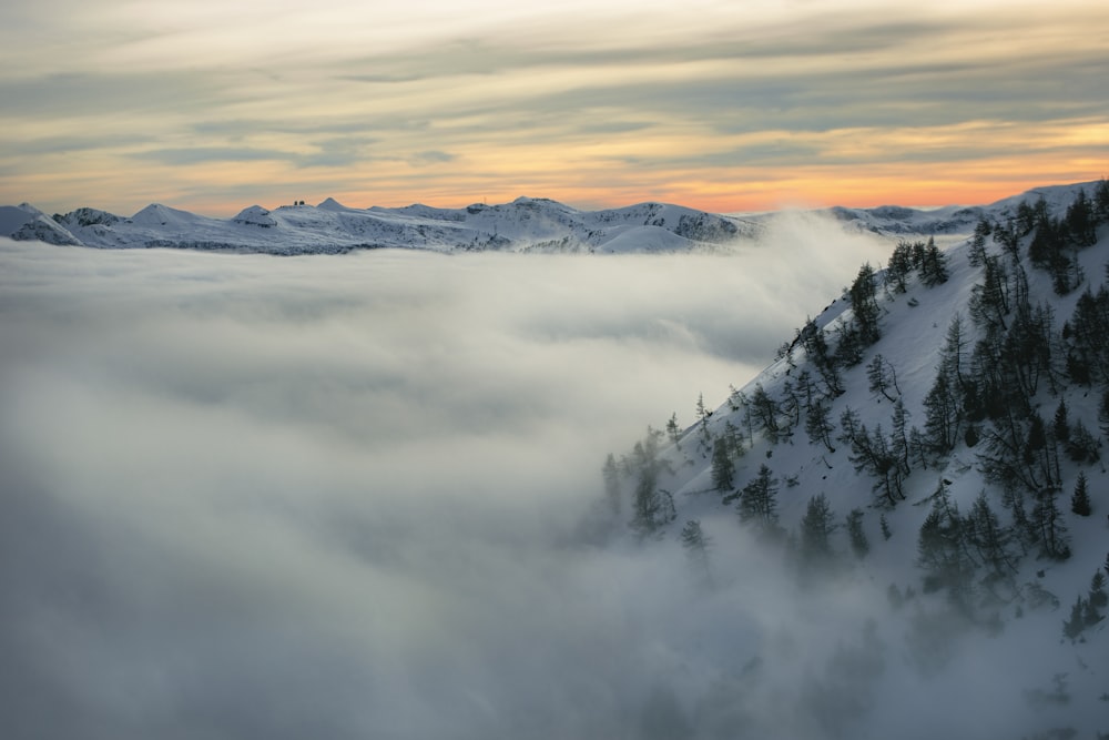 a mountain covered in snow and surrounded by clouds