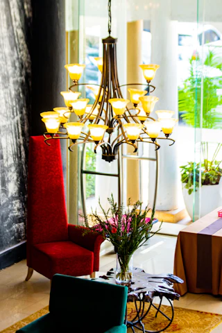 A cozy living room softly illuminated by an elegant chandelier and matching wall sconces from Lumiara.