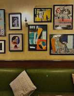 A cozy corner showcasing a framed abstract painting alongside a stylish piece of clothing from the collection.