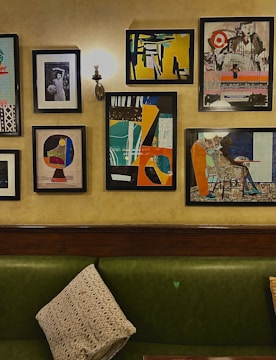 Living room wall featuring a trio of 20x30 personalized canvas paintings with vibrant designs