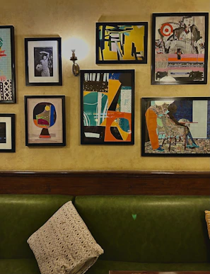 A cozy corner showcasing a framed abstract painting alongside a stylish piece of clothing from the collection.