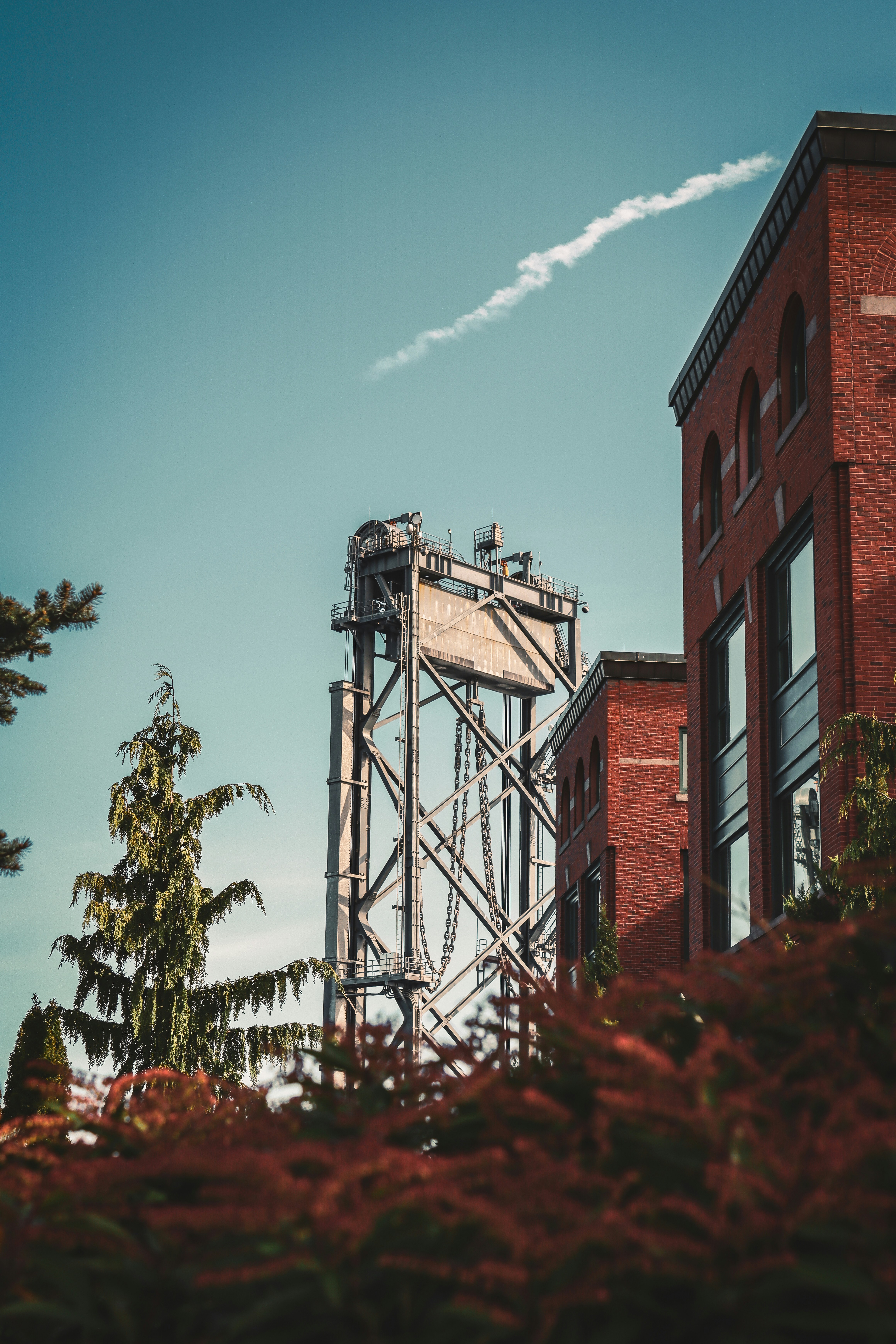 a tall metal structure sitting next to a tall brick building