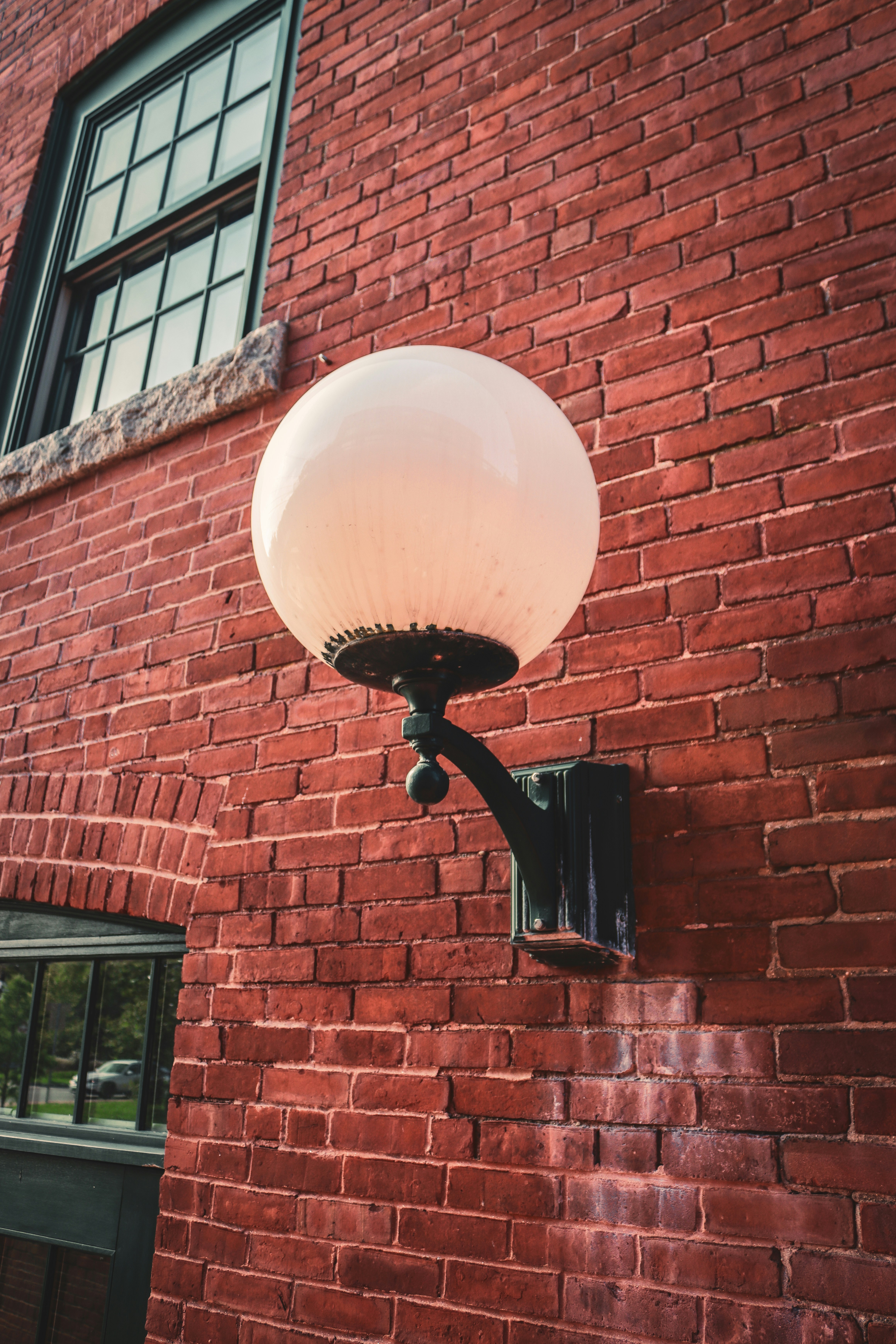 a lamp on the side of a brick building