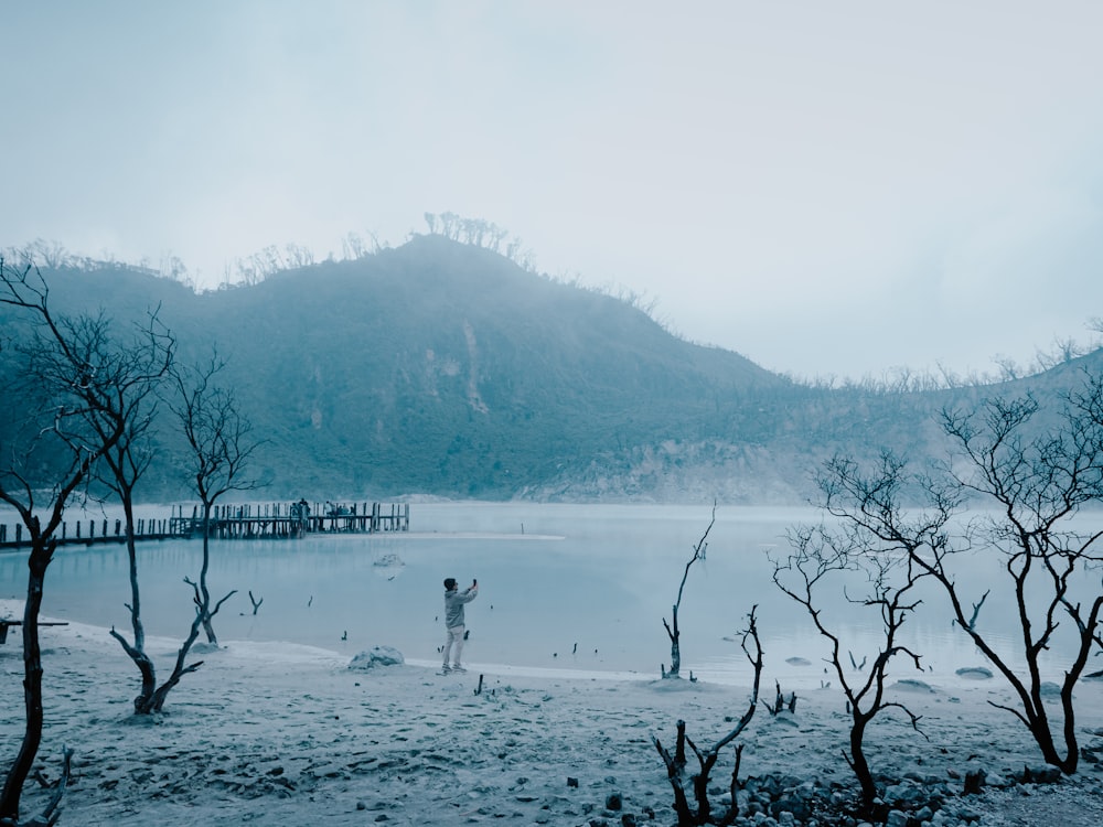 a person standing on a beach near a body of water