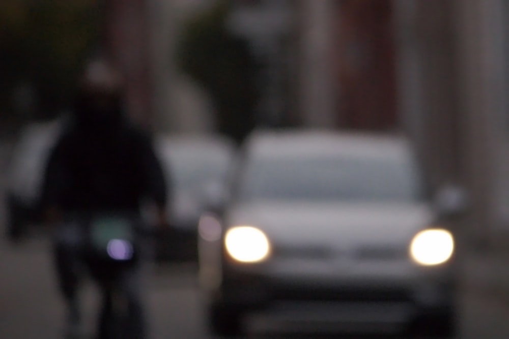 a blurry photo of a car and a person on a bike