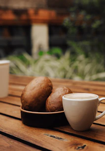 A warm, inviting café scene with fresh bread and steaming coffee on a rustic wooden table.