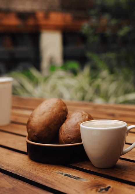 A warm, inviting café scene with fresh bread and steaming coffee on a rustic wooden table.