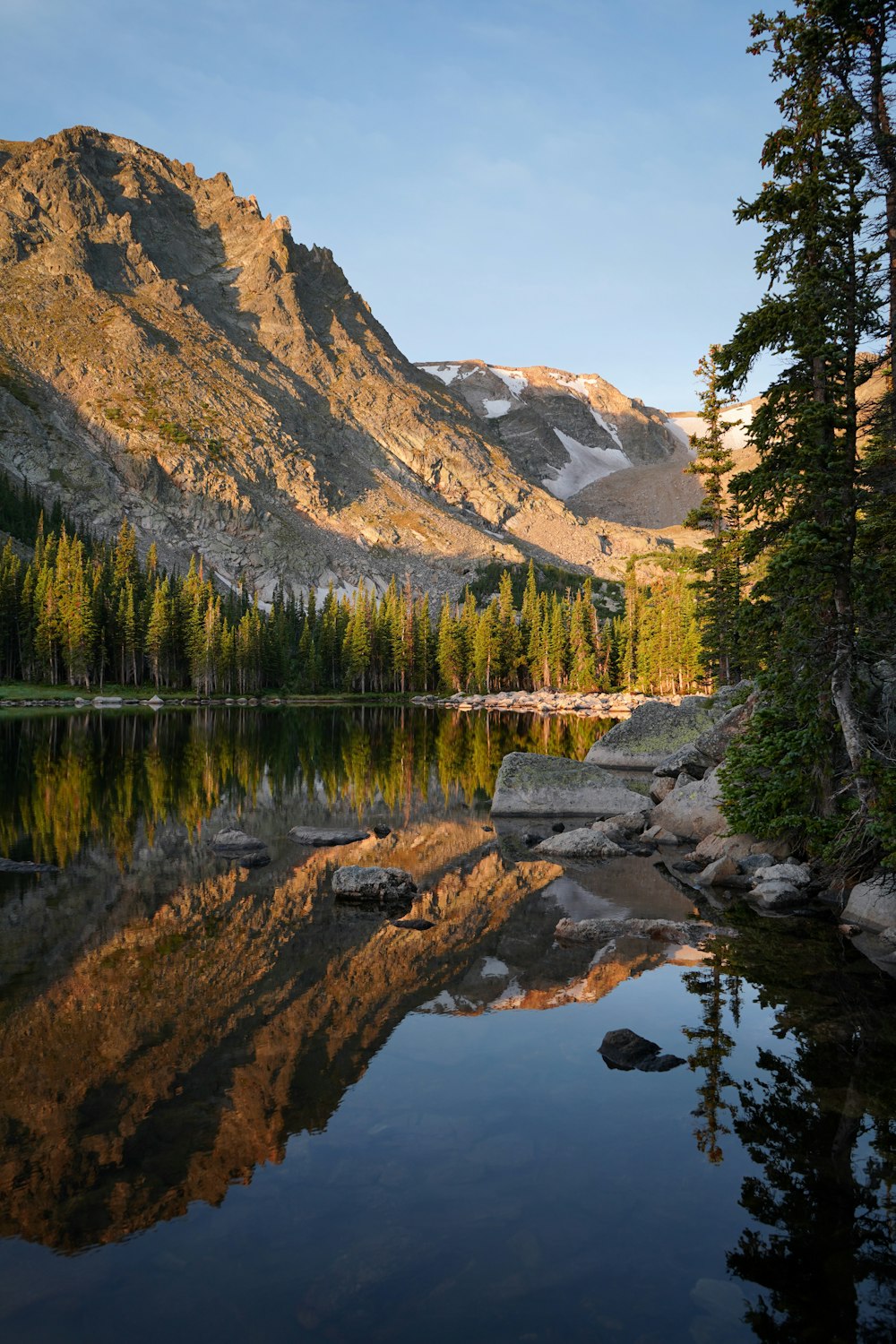 Ein See, umgeben von Bergen und Bäumen