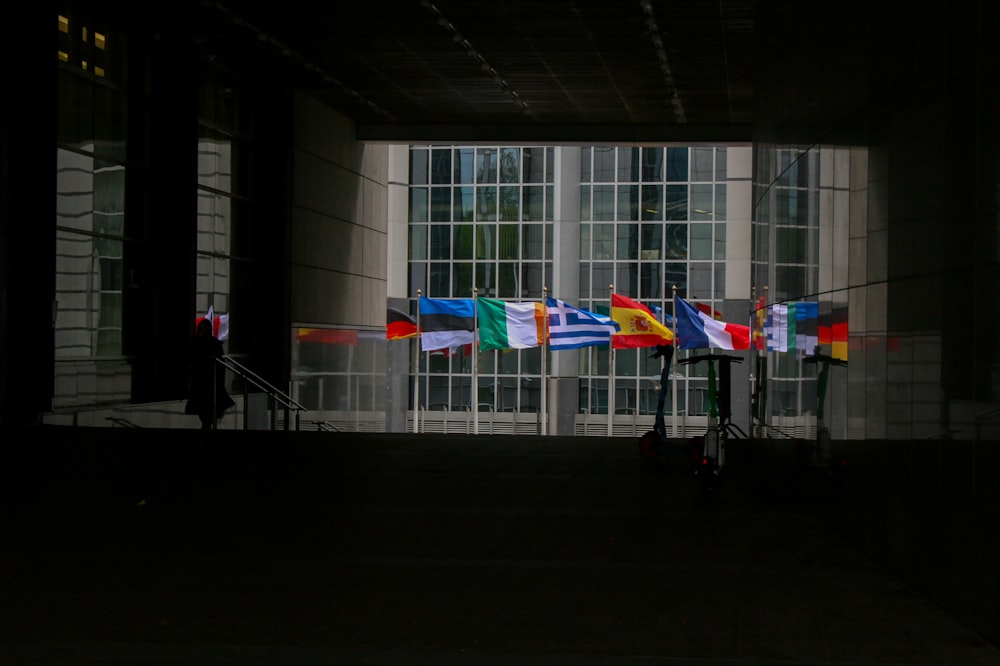 a group of flags hanging from the side of a building