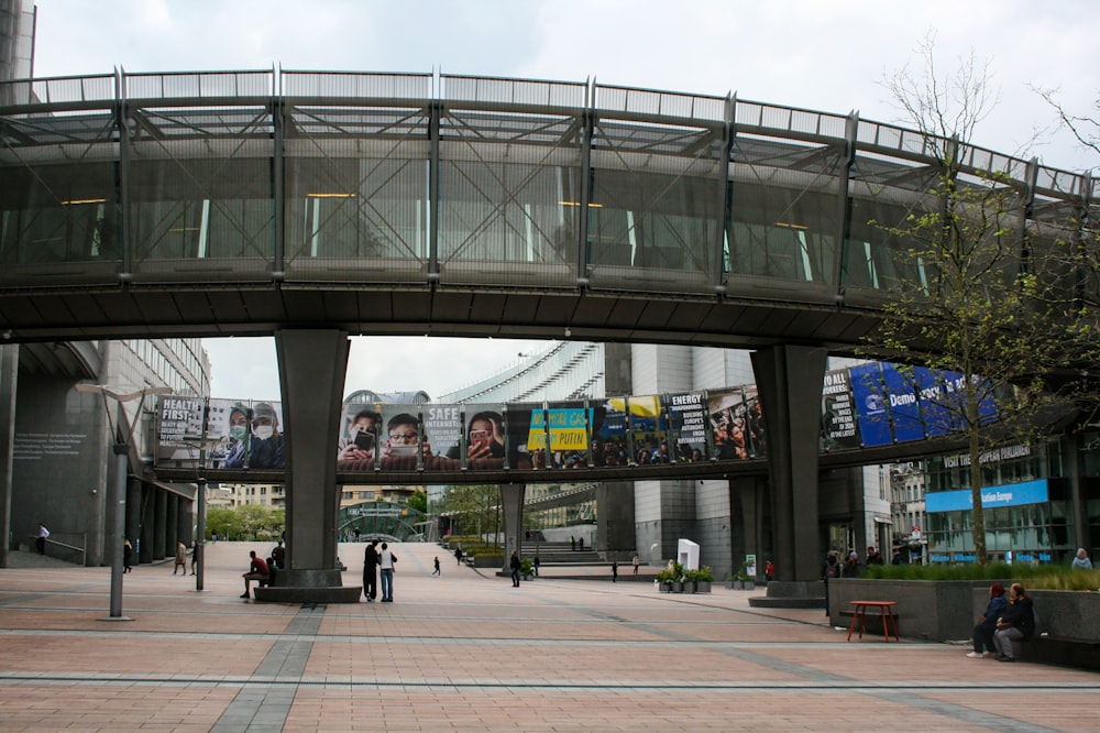 a pedestrian bridge over a street with people walking on it