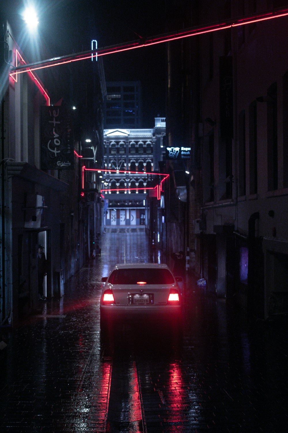 a car driving down a street at night