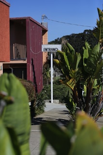 A welcoming office entrance with a sign that reads 'Reel Reef Properties' surrounded by tropical plants.