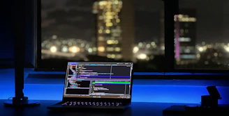 A modern workspace with a laptop showing a tutorial video on AI tool usage, bathed in soft electric blue light.