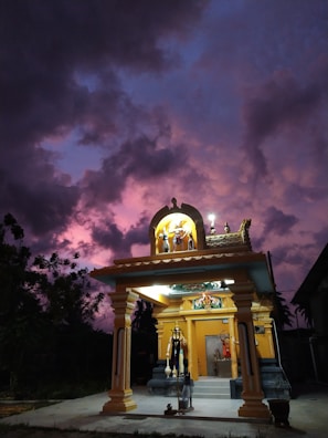 Evening temple facade illuminated with warm lighting against a deep indigo sky.