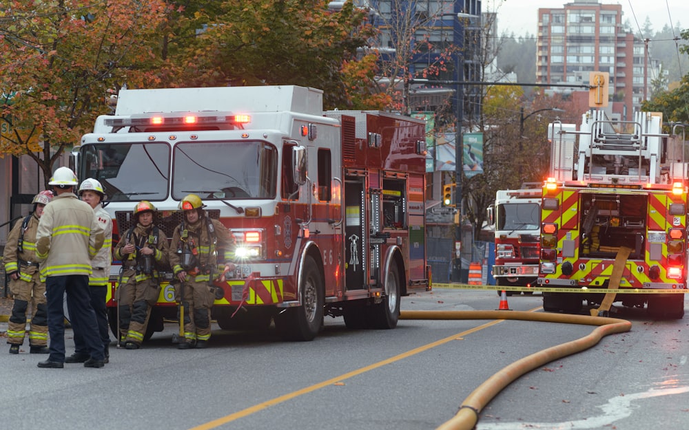 a group of fire fighters standing next to a fire truck