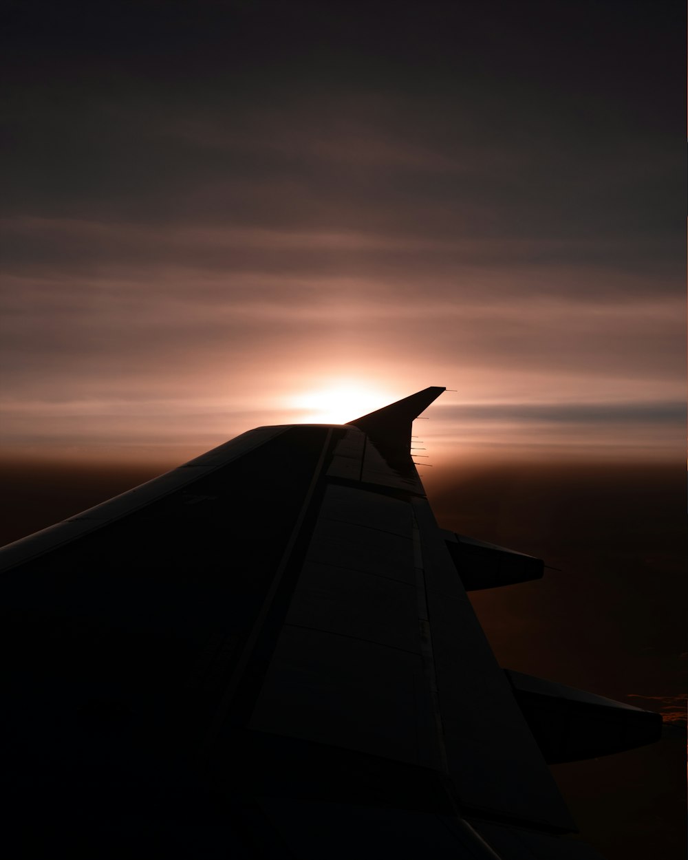 the wing of an airplane as the sun sets