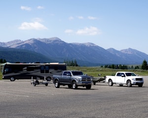 A wide, open storage lot with various RVs and boats parked under a clear blue sky.