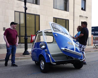 A friendly team member assisting a donor with car keys in front of a donated vehicle in the Bronx neighborhood.