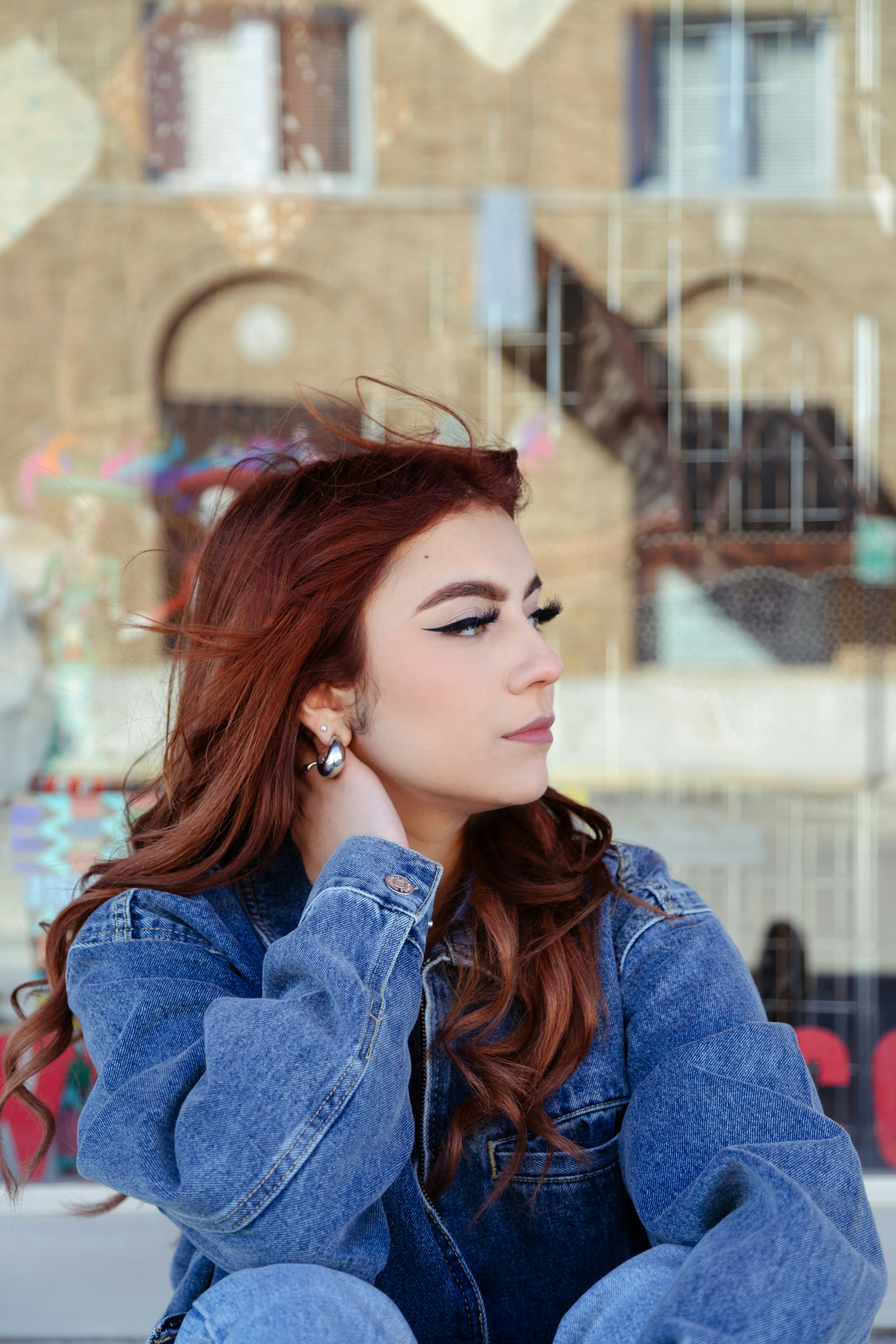 a woman with red hair sitting on the ground