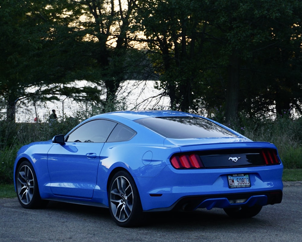 a blue mustang parked in a parking lot