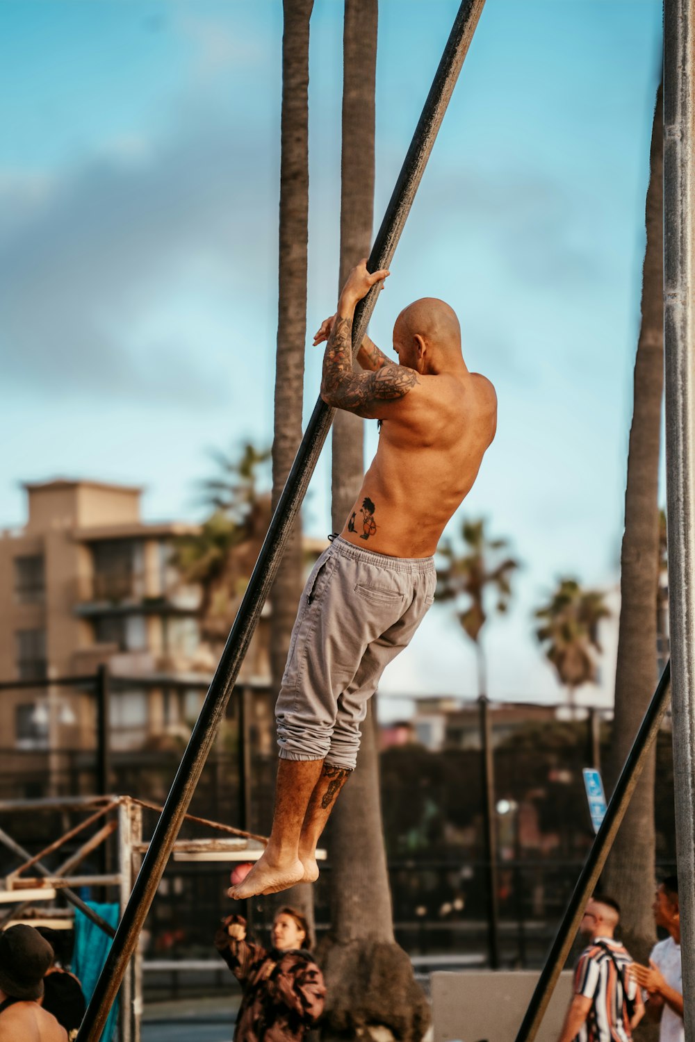 a man climbing up a pole on a beach