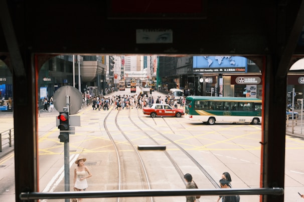 A driving instructor patiently guiding a student through a busy city intersection.