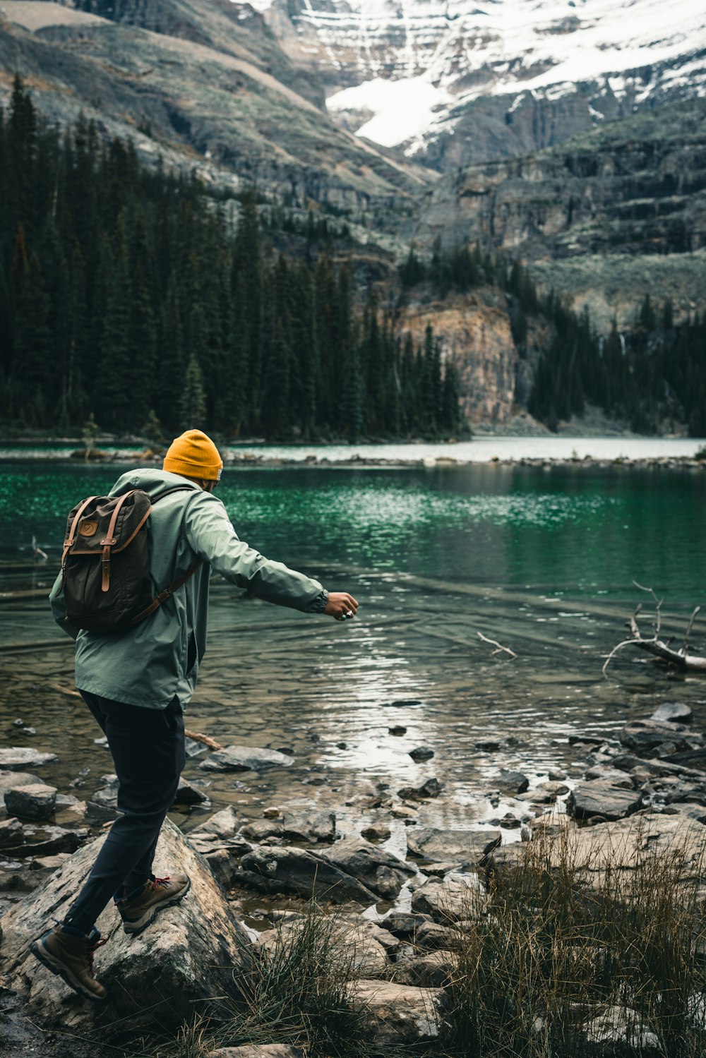 uma pessoa em pé em uma rocha perto de um lago