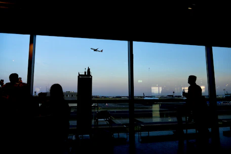 Business travelers boarding a modern airplane at sunrise.