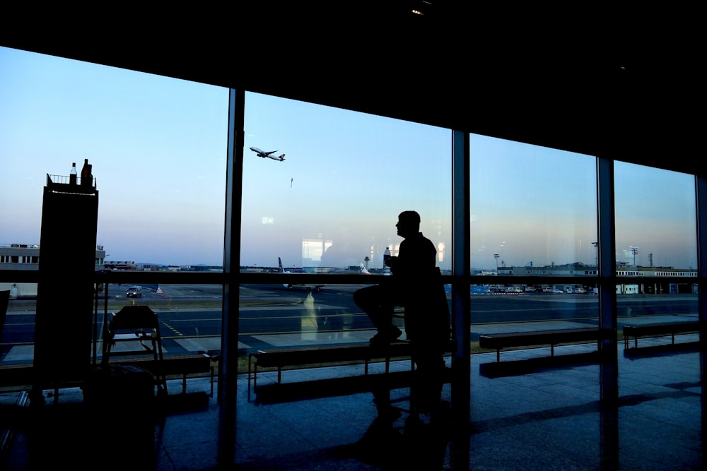 a silhouette of a person sitting in an airport