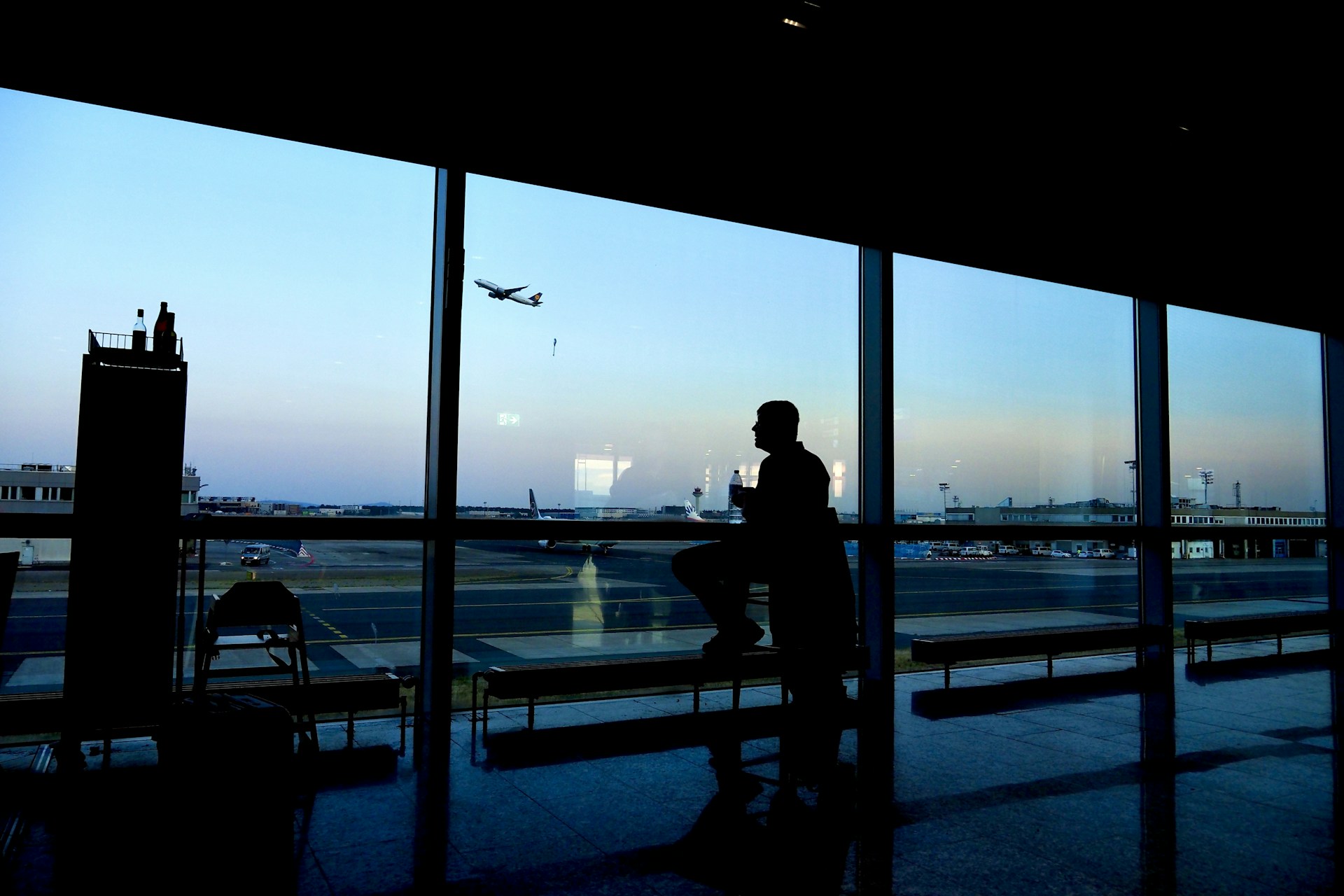 a silhouette of a person sitting in an airport