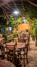 Cozy farmhouse dining area with wooden tables set for a group meal in summer.