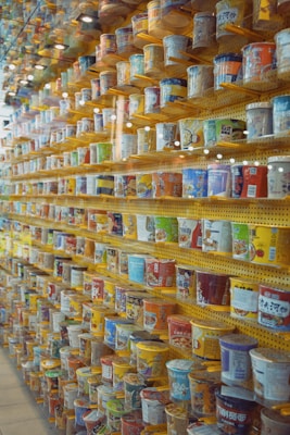 A colorful assortment of ramen noodle packages from various countries stacked neatly on a wooden table.