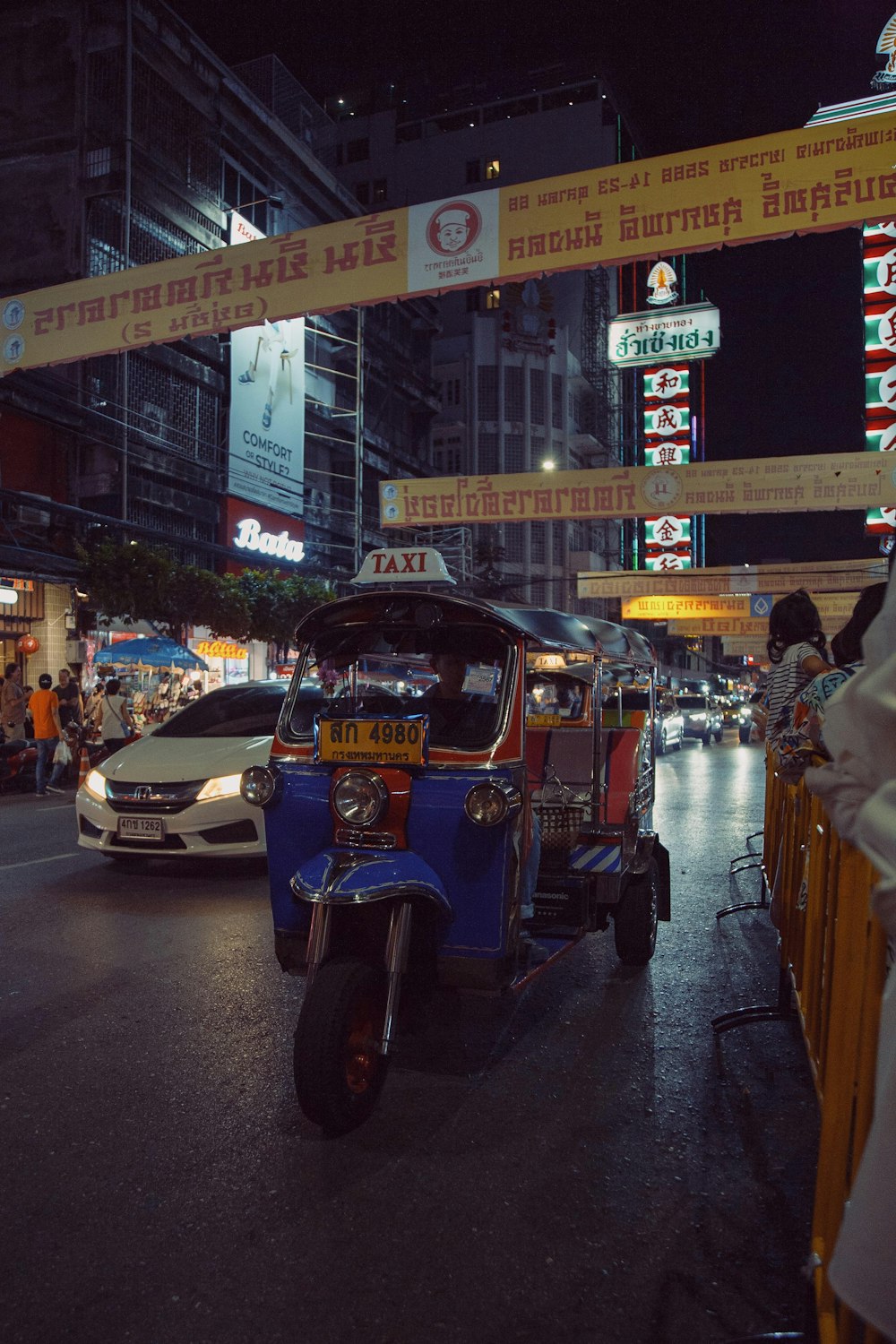 an auto rickshaw driving down a street at night