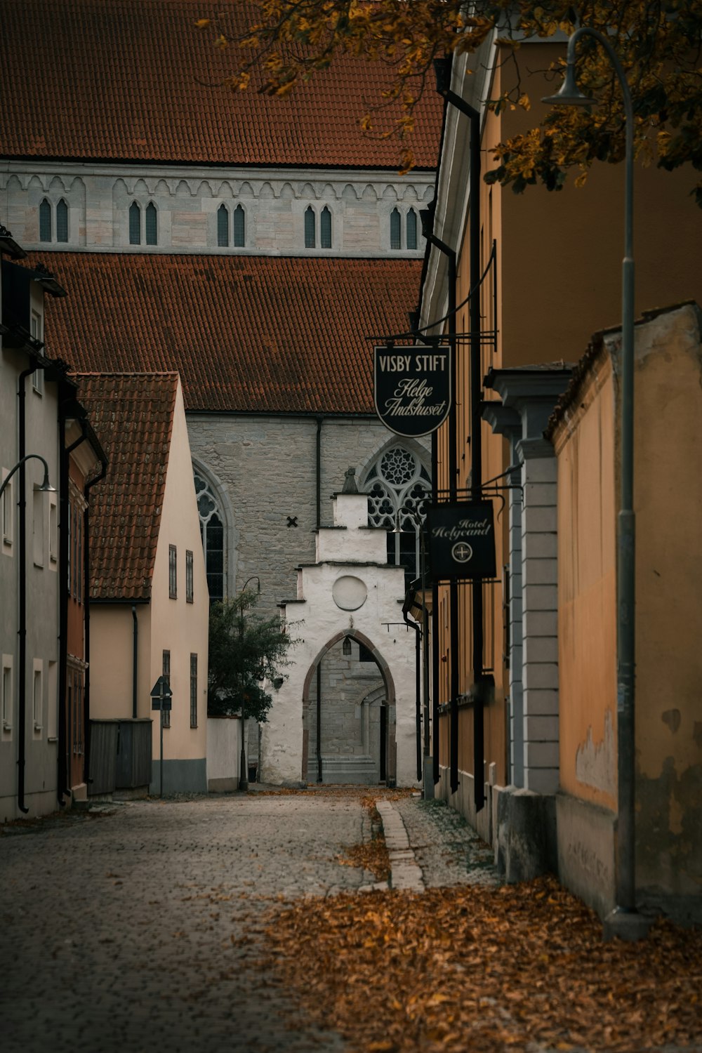a narrow street with a church in the background