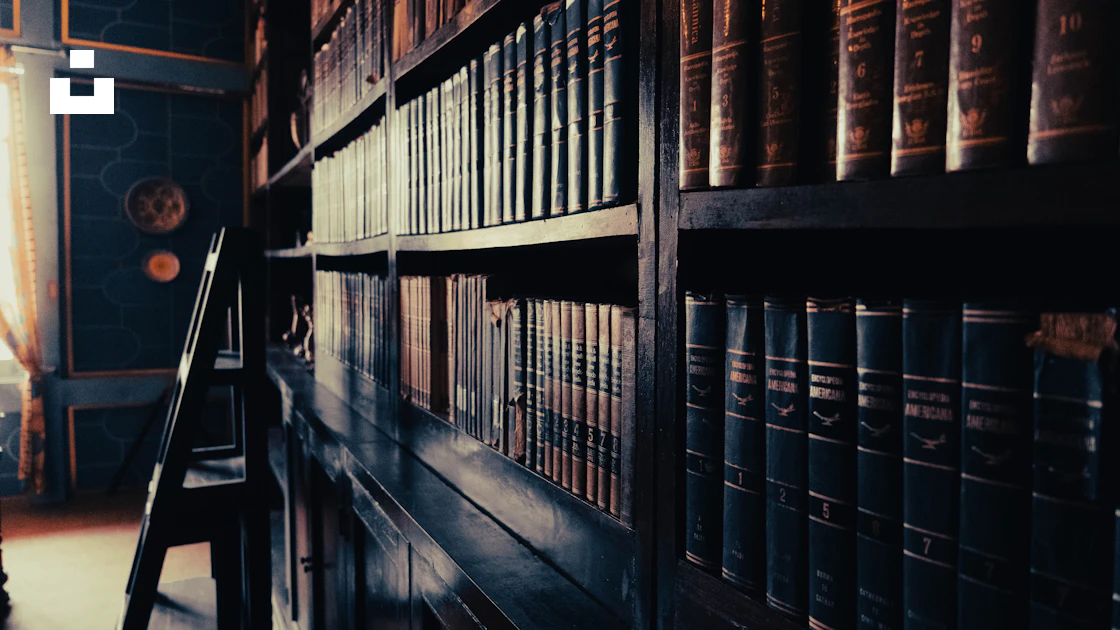 A row of books on a shelf in a library photo – Free Shelves Image on ...