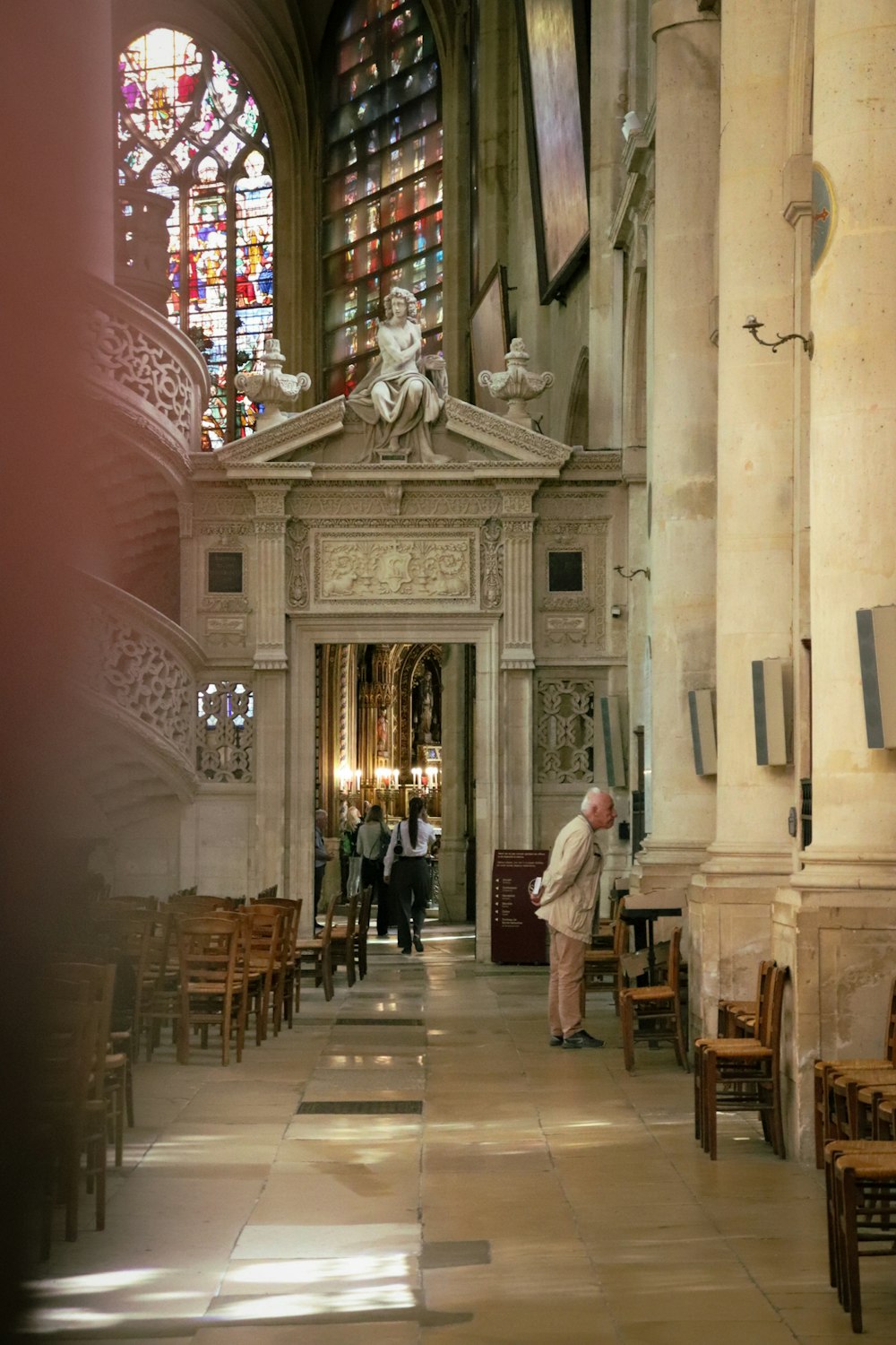 Ein Mann steht in einer Kirche mit Buntglasfenstern