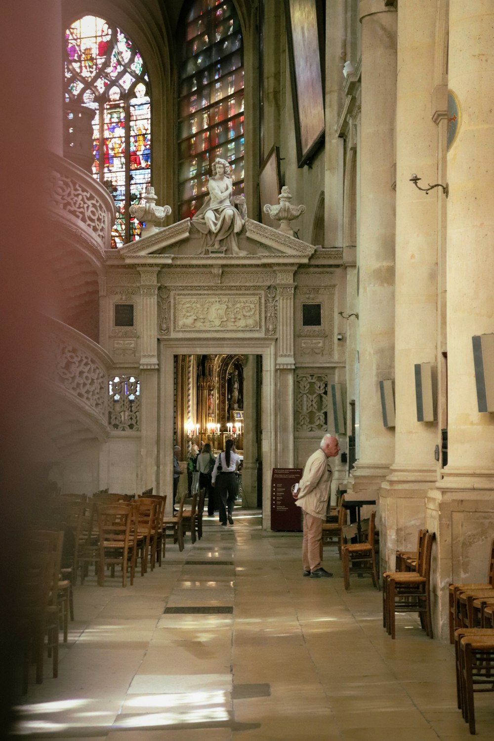 a man is standing in a church with stained glass windows