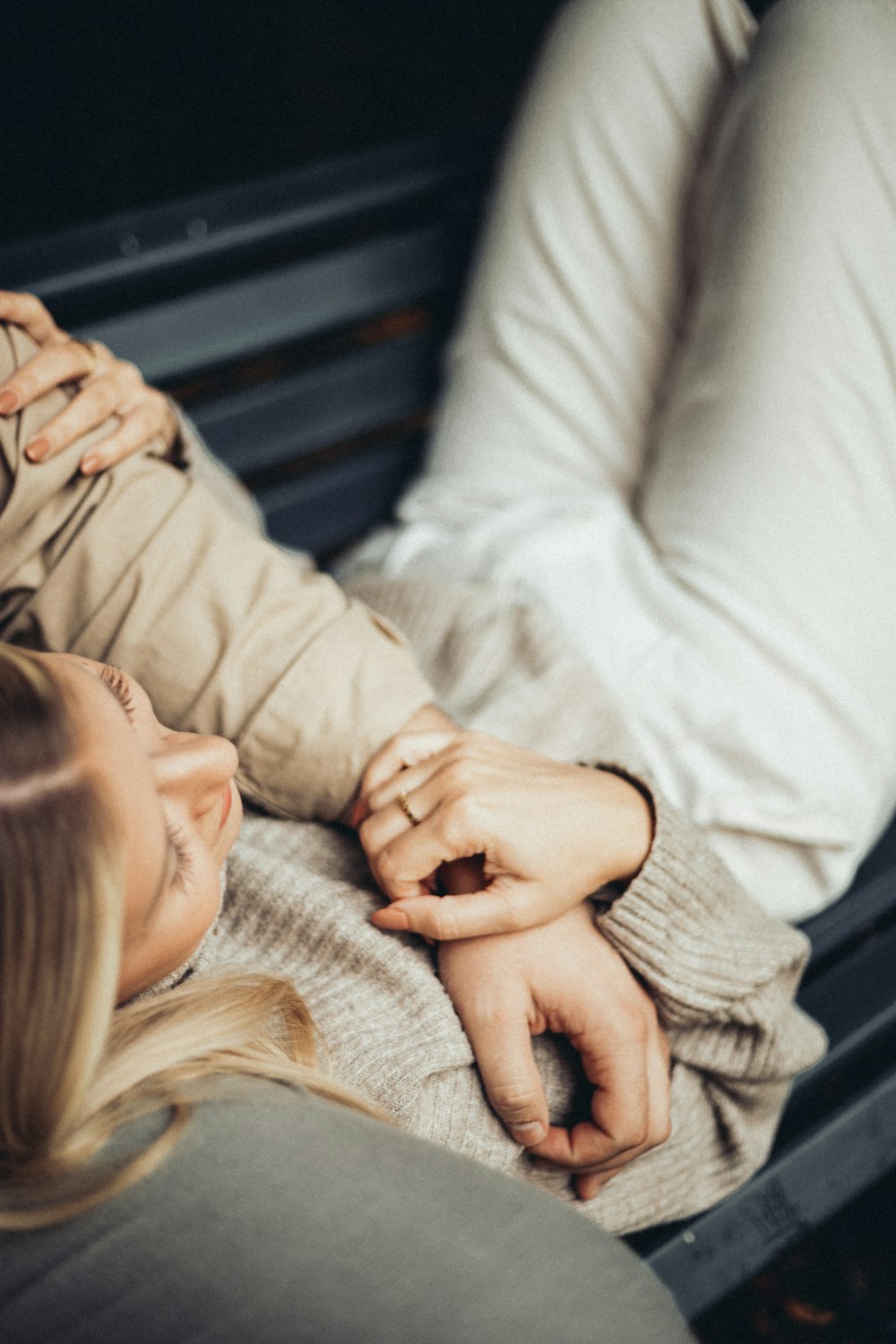 a man and a woman laying on a bench