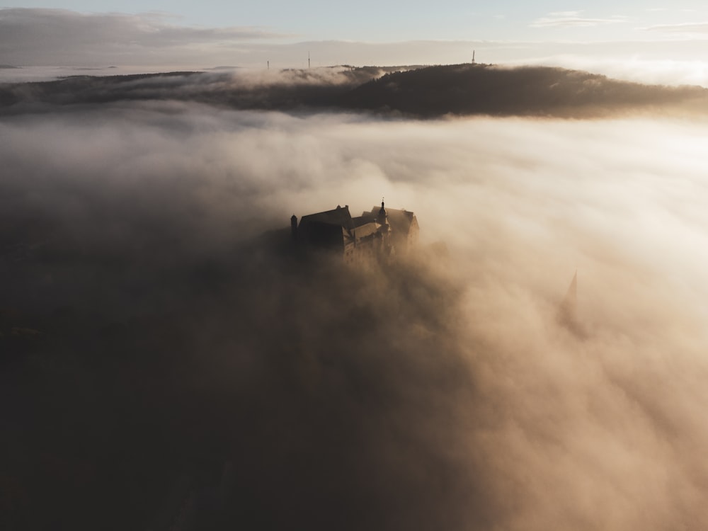 a castle in the middle of a foggy sky