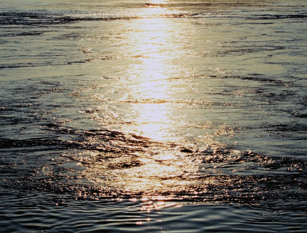 a large body of water with a boat in the distance