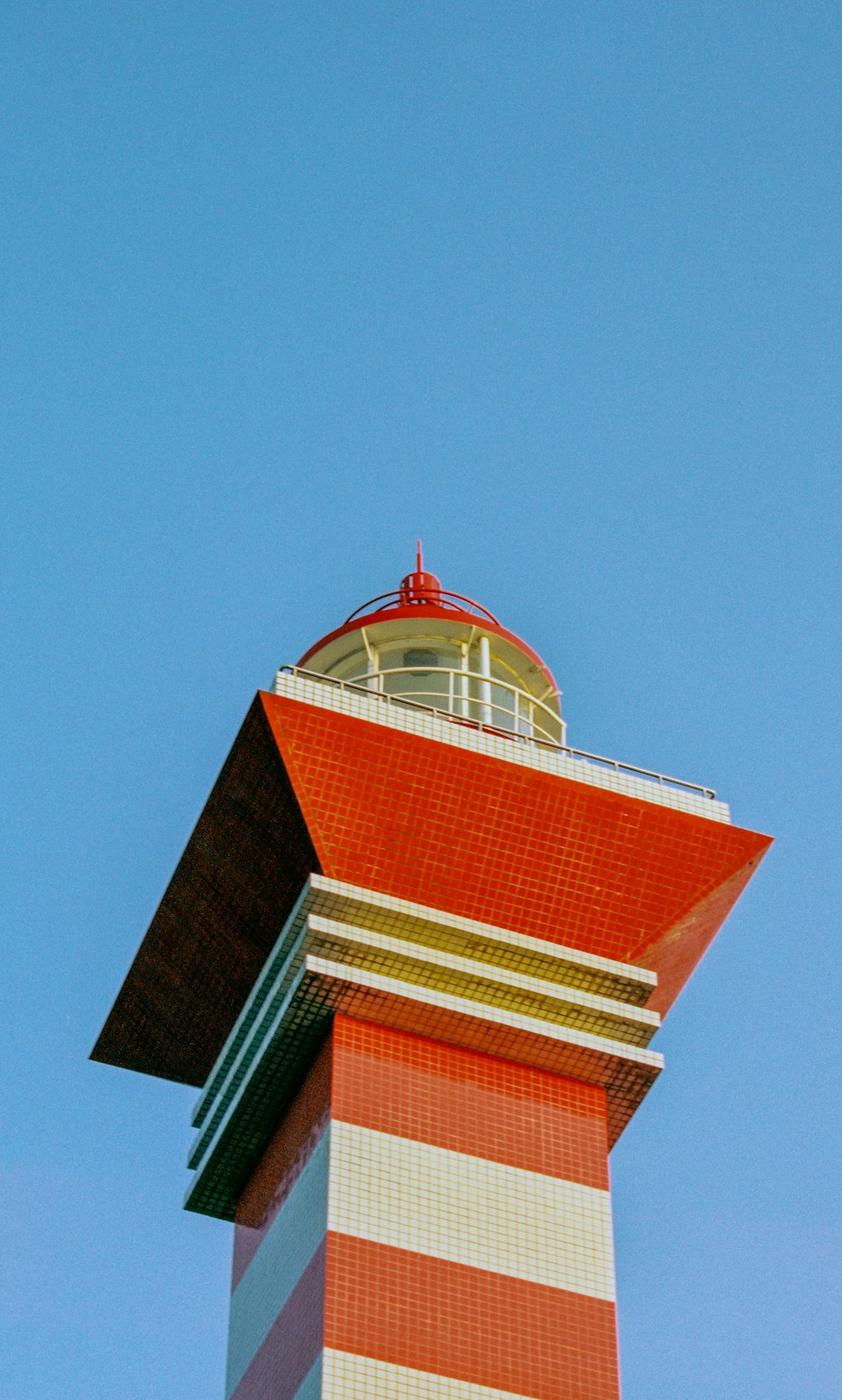 a tall red and white tower with a clock on top