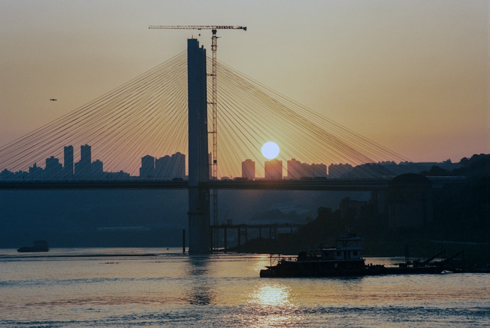 a boat traveling across a river under a bridge