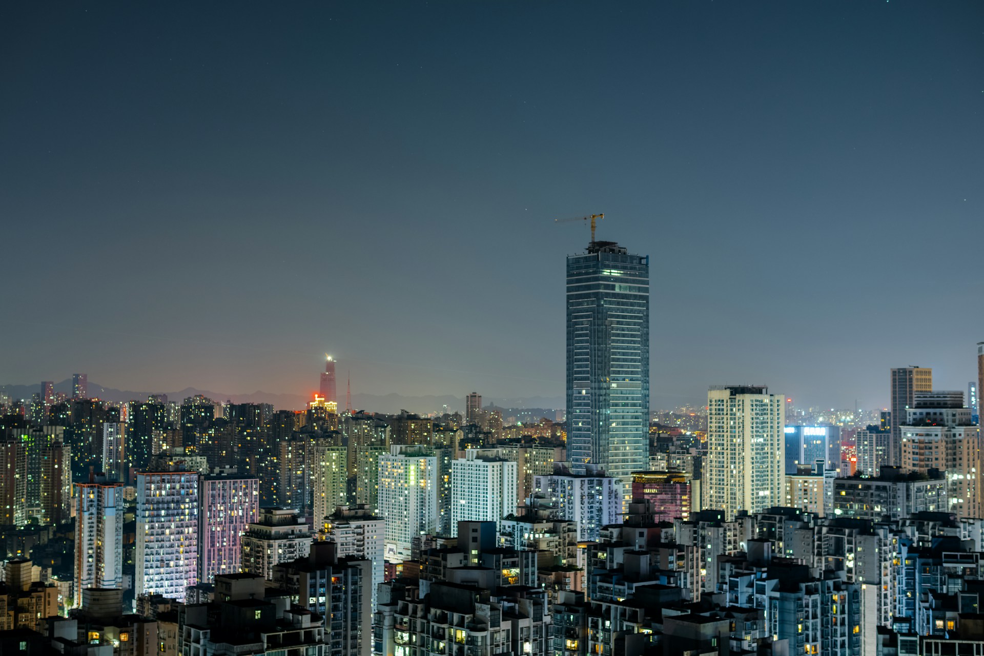 a view of a city at night from the top of a hill