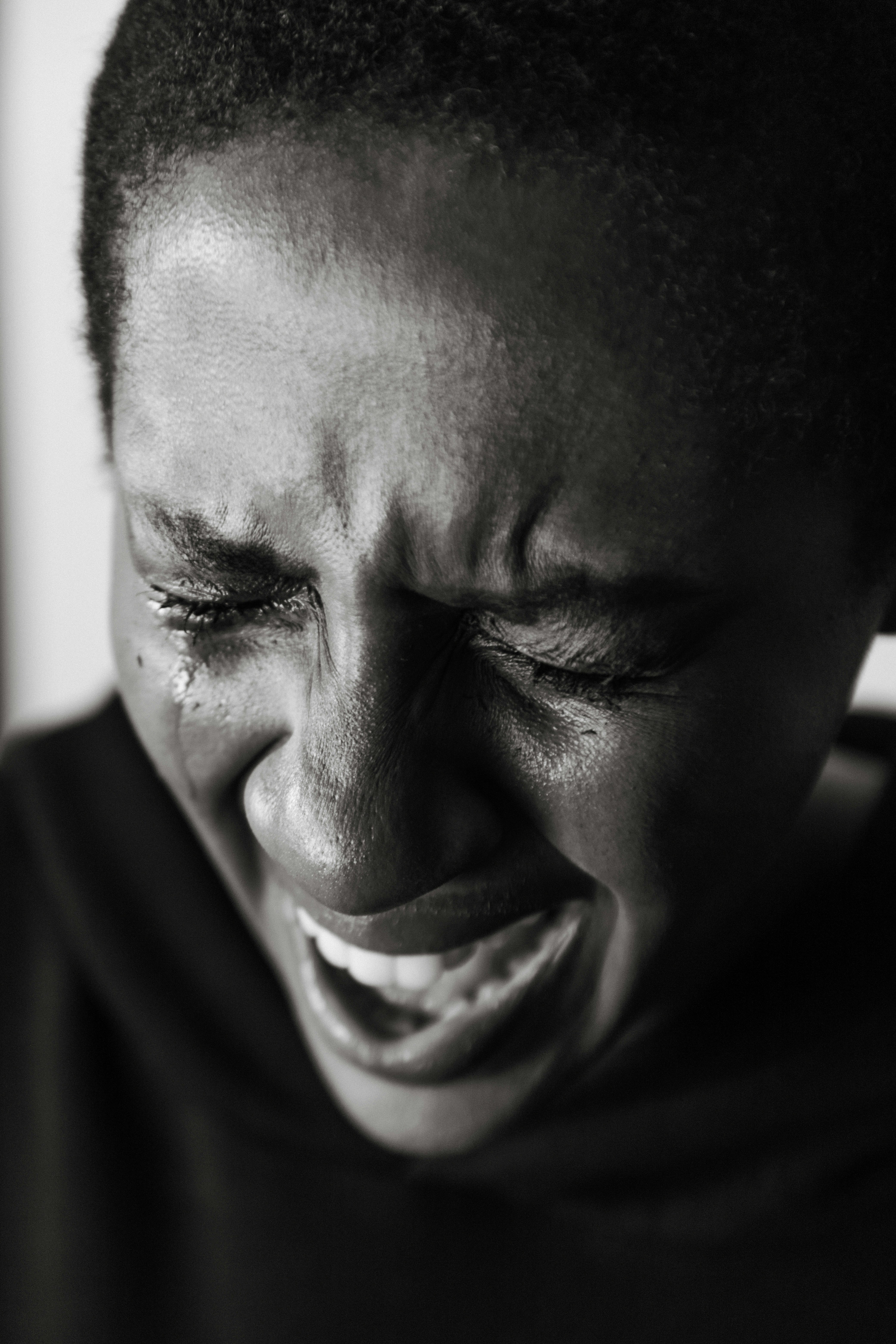 A black girl holding her head and crying